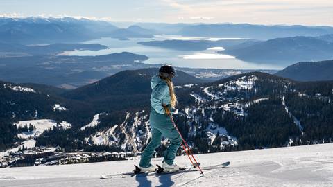 Skier at the top of a run looking out to Lake Pend Oreille