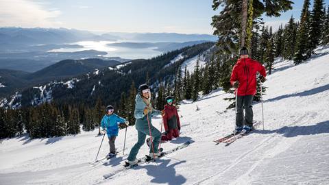 group of riders smiling while stopped on the slopes at Schweitzer