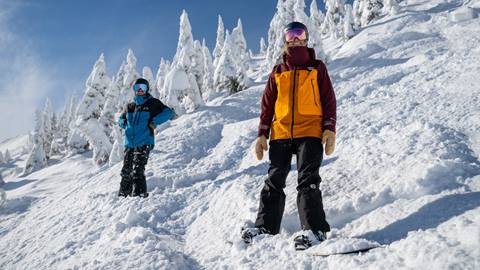 two snowboarders smiling on the slopes 