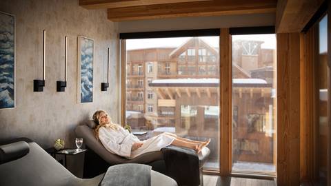 Woman reclining in a quiet relaxation lounge at Cambium Spa at Schweitzer, experiencing peaceful downtime as part of luxurious day spa treatments. 