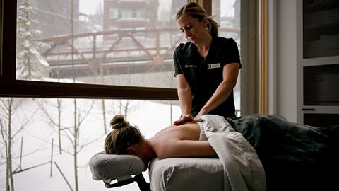 woman getting massage at Cambium Spa with snow falling in the background