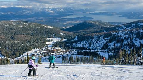 family skiing down slope at Schweitzer