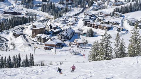 two people skiing toward Schweitzer village