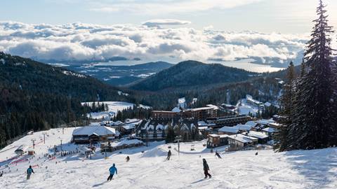image of skiers and snowboarders riding down slopes toward Schweitzer village