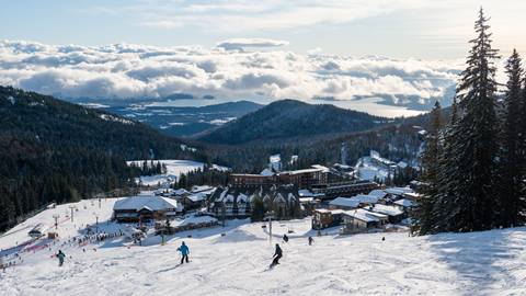 image of skiers riding down ski run toward Schweitzer Village