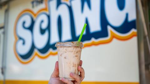 image of horchata in plastic cup being held up in front of Schwagon