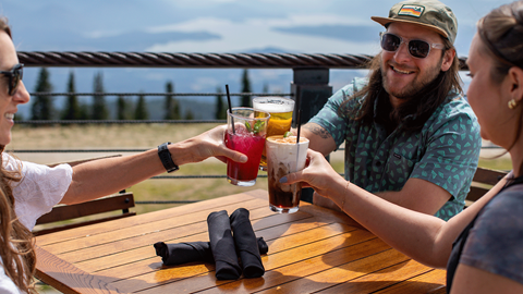 three people cheers-ing their glasses at Sky House on the patio