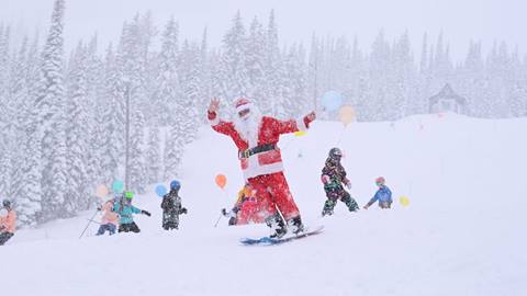 santa skiing in snow with kids for a balloon parade at Schweitzer