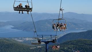 People on chairlift at Schweitzer with beer raising their glasses to other people