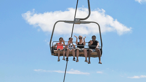 group of smiling people on chairlift