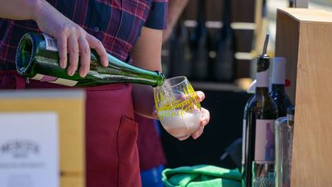 wine being poured into souvenir winefest wine glass at schweitzer