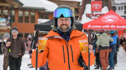 Skier smiling with beers in hand at Schweitzer's MLK weekend festivities