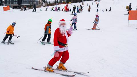 image of santa skiing at Schweitzer, leading parade of kids down the slopes