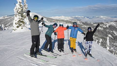group of people smiling on the slopes at Schweitzer