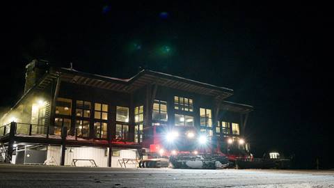 Snow cat parked in front of Sky House at Schweitzer at night