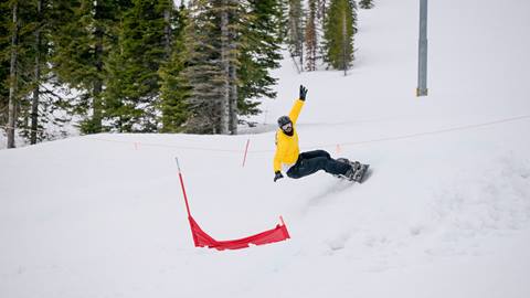 snowboarder racing down banked slalom course at Schweitzer