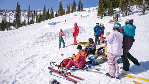 skiers and riders watching contestant race down banked slalom course at Schweitzer