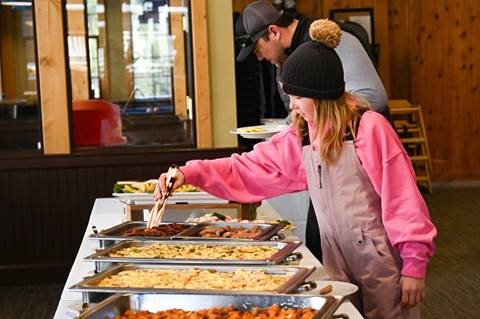 Guests help themselves to a variety of hot buffet options during a lunch service at Schweitzer.