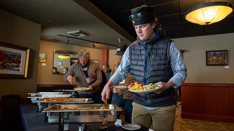 person serving themselves food in buffet line at Schweitzer