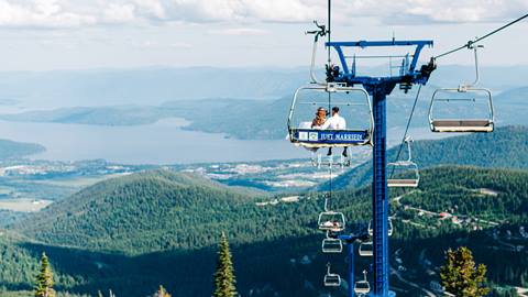 couple riding on chairlift with just married sign on the back