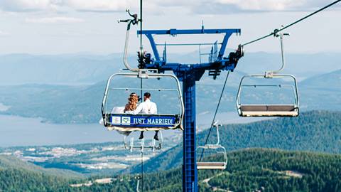 couple on chairlift with just married sign on the chair