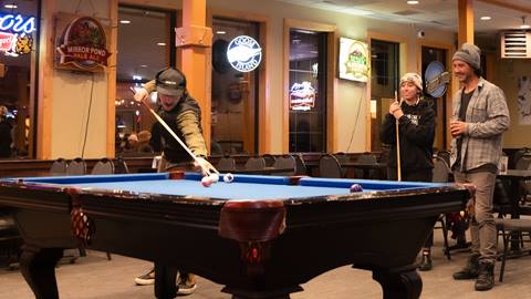 Ski club members playing pool at Schweitzer Mountain.