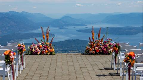 view of wedding set up for wedding with orange florals and view of lake pend oreille