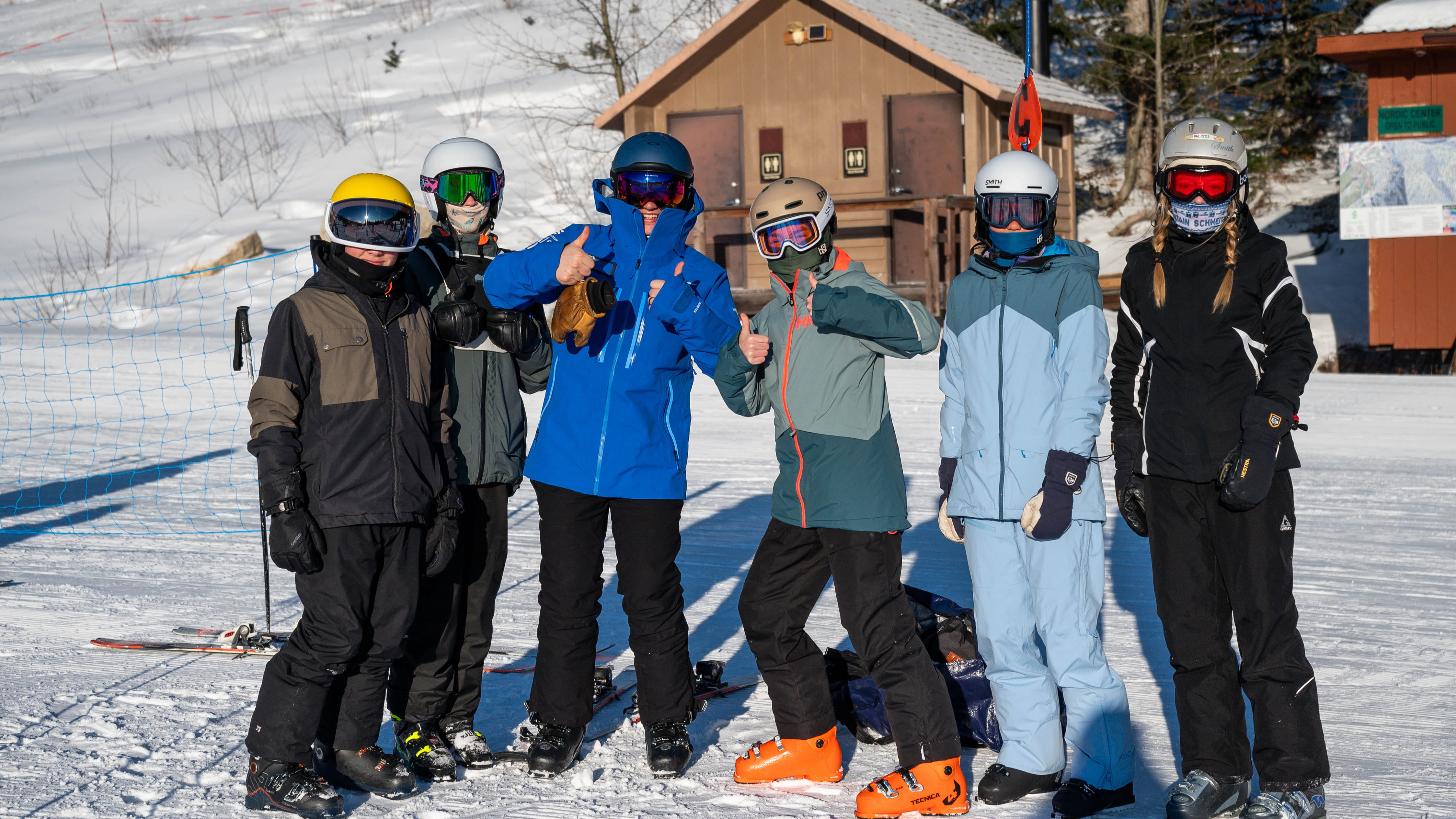 smiling group of students with ski instructor