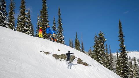 kid going off cliff in freestyle camp at Schweitzer