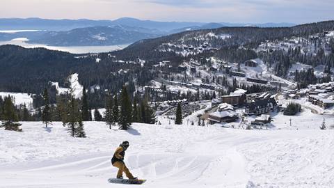 a snowboarder rides at schweitzer mountain resort, after schweitzer snowboarding & ski lesson guides