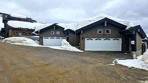 Vacation rental homes at Schweitzer with snow on rooftops and private garages along a winter road