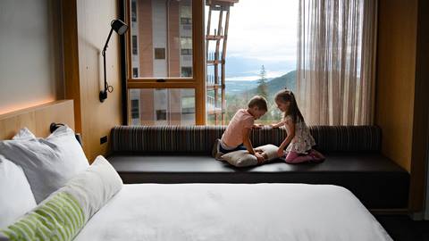 Two kids looking out the window at Schweitzer's Humbird hotel lodging