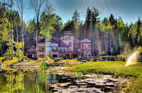 Scenic lakeside view of Talus Rock Retreat vacation rental near Schweitzer surrounded by forest and sunshine