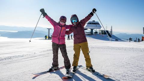 two skiers happy with arms in the air