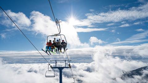 group of people smiling and happy on chairlift at Schweitzer