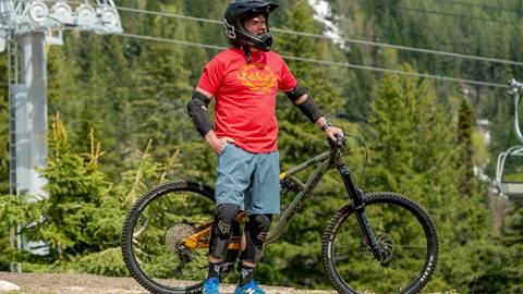man with helmet and protective pads near mountain bike
