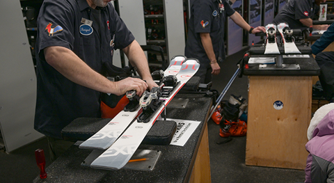 a technician tuning skis at schweitzer as part of the ski rentals service