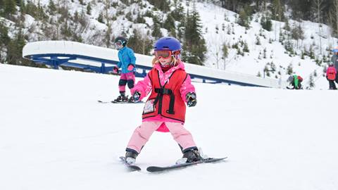 a young girl in ski rentals practices skiing on a gentle slope at schweitzer mountain