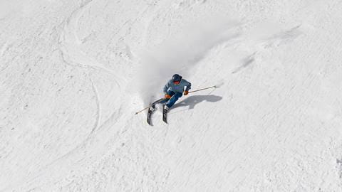 Skier carving on a groomed slopes