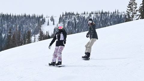 two snowboarders riding a slope at Schweitzer with snowboard rentals 