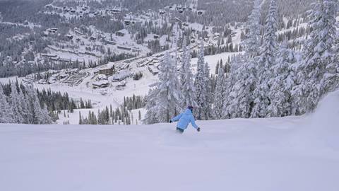 two skiers on a chairlift at Schweitzer with blue skies in the background