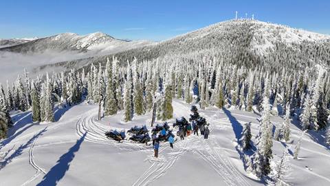group of people snowmbiling in Selkirk Mountains