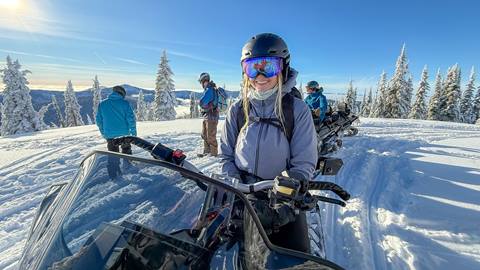 girl smiling while riding snowmobile on schweitzer mountain snowmobile tours