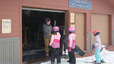 ski storage employee helping guests store gear at schweitzer