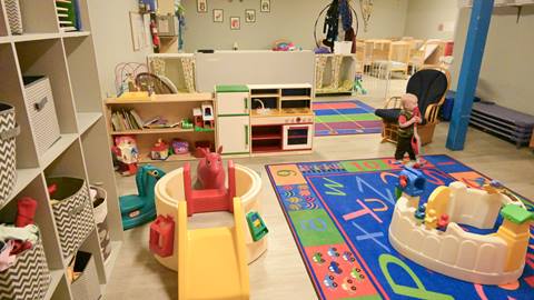 the indoor playroom at the schweitzer children's center features colorful activity stations and toys