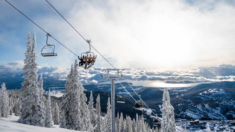 image of people riding chairlift at Schweitzer with view of Lake Pend Oreille