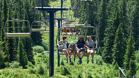 a family rides a scenic chairlift up the mountain during a day at the Schweitzer Activity Center.