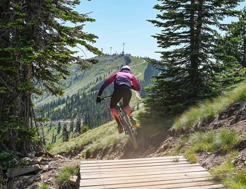a cyclist catches air on a trail jump using high-performance mountain bike rentals at Schweitzer