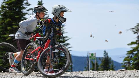two young riders with their kids bike rental and youth mountain bikes look out over schweitzer