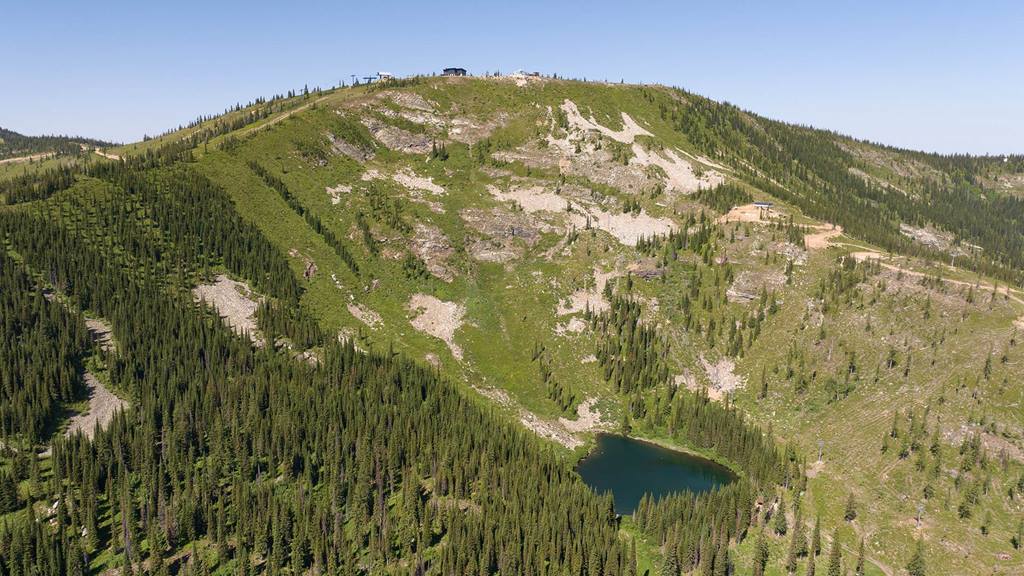 Drone view of the Outback Bowl in summer at Schweitzer including views of Sky House at the summit and Colburn Lake.
